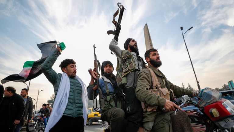 Syrian opposition fighters celebrate after the Syrian government collapsed in Damascus, Syria, Sunday, Dec. 8, 2024. (AP Photo/Omar Sanadiki)