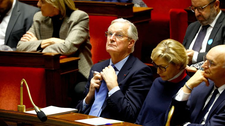 French Prime Minister Michel Barnier adjusts his tie as he attends a debate on two motions of no-confidence against the French government.
Pic: Reuters