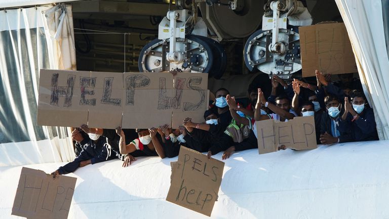 Migrants remaining on the rescue ship Geo Barents hold banners after Italy allowed the disembarkation of children and sick people, in the port of Catania, Italy, November 7, 2022. REUTERS/Antonio Parrinello