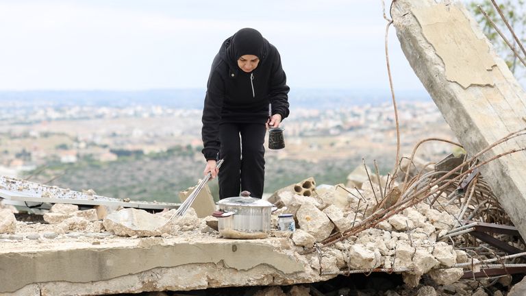 A displaced Lebanese woman stands on rubble near her destroyed home in Zibqin, southern Lebanon. Pic: Reuters