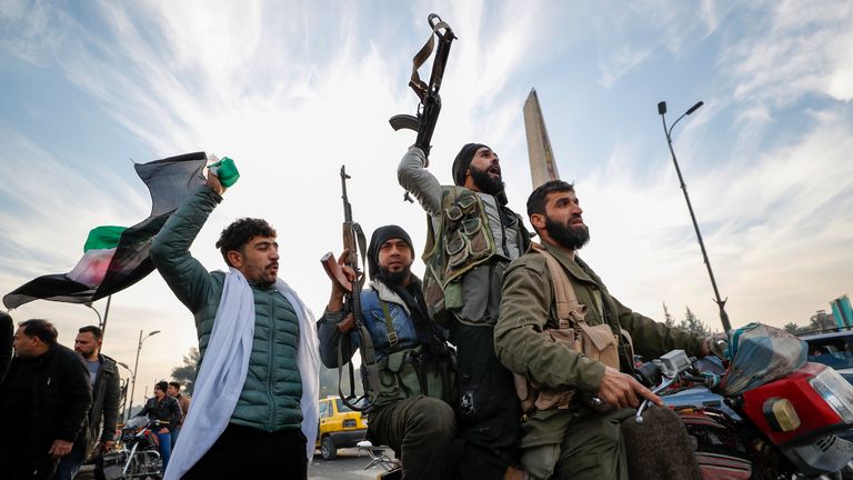 Syrian opposition fighters celebrate the collapse of the government in the capital Damascus. Pic: AP