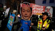 A participant wearing a mask of South Korean President Yoon Suk Yeol attends a rally demanding his impeachment outside the National Assembly in Seoul, South Korea, Sunday, Dec. 8, 2024.The signs read "Arrest Yoon Suk Yeol." (AP Photo/Ahn Young-joon)